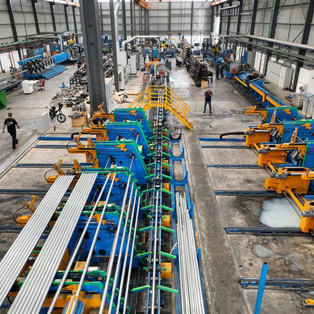 Aerial view of a large manufacturing plant interior with machinery and workers.